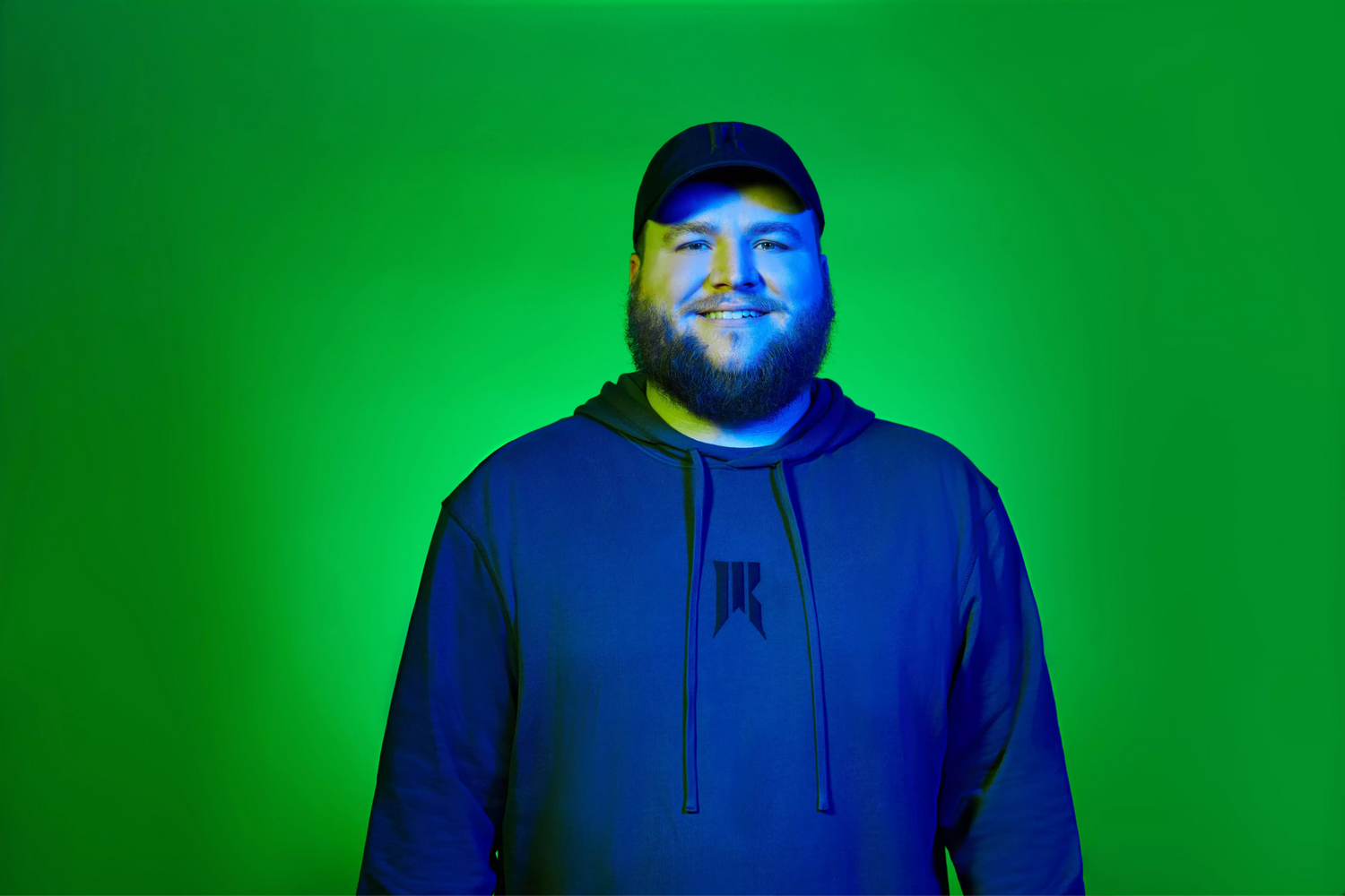 Player (Bestman) with a Rebellion hoodie and a green background