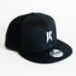 Black Rebellion x New Era snapback hat with white embroidered logo on a white background